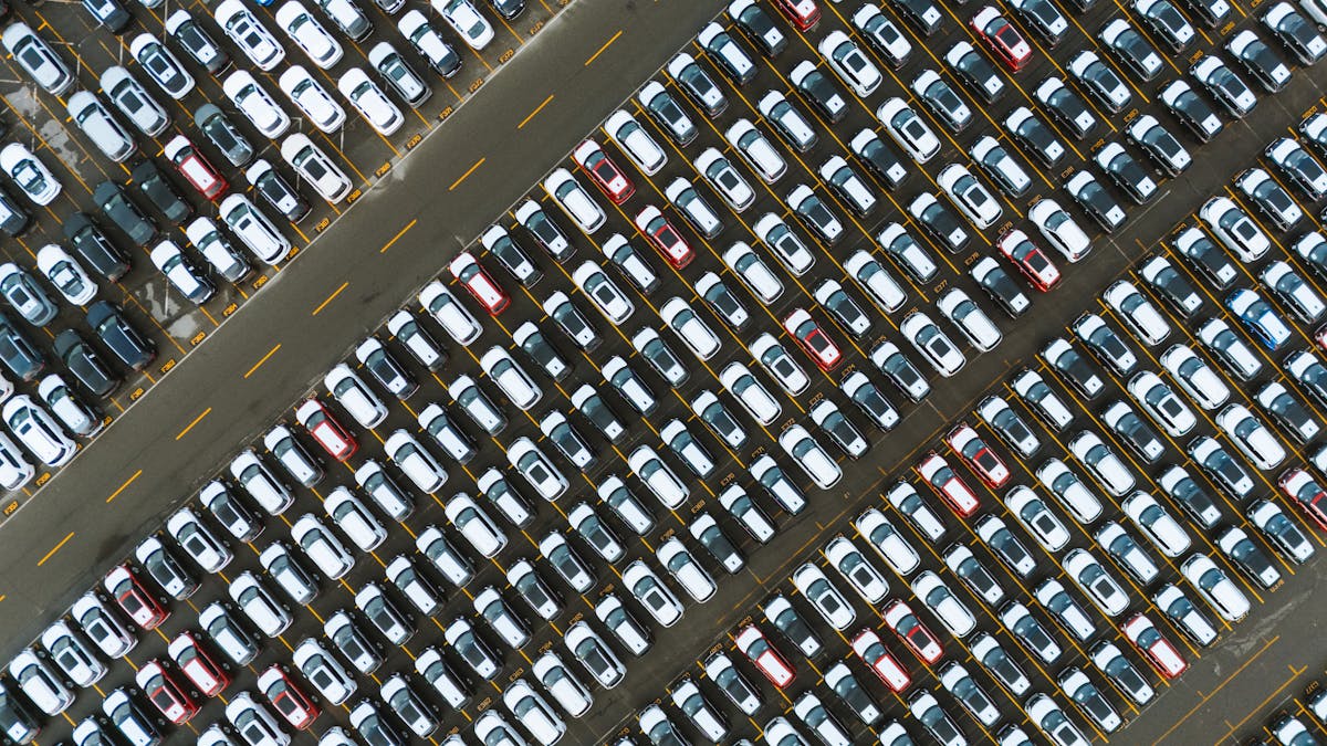 Vue aérienne d'un grand parking rempli de véhicules alignés en rangées